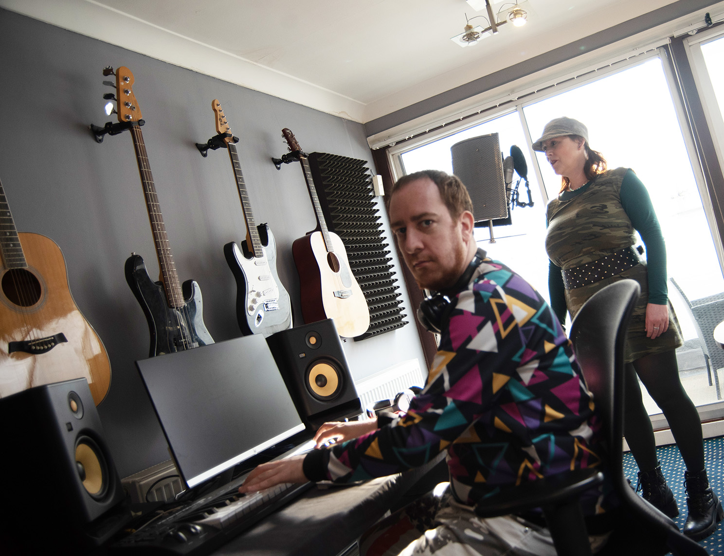A participant and music mentor working together in a professional recording studio